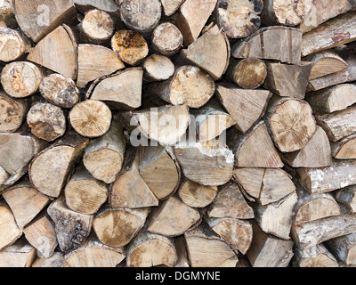 Close up detail of split round logs stacked in a single row Stock Photo