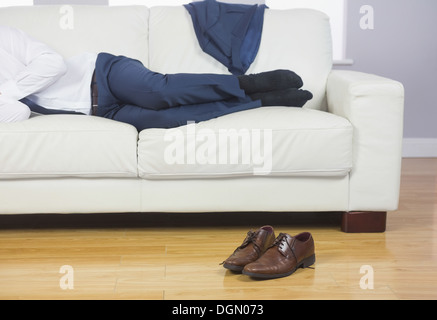 Close up of male legs lying on couch Stock Photo