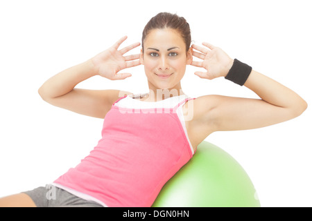 Content sporty brunette doing sit ups on exercise ball Stock Photo