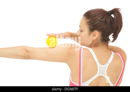 Rear view of sporty brunette touching arm with yellow massage ball Stock Photo