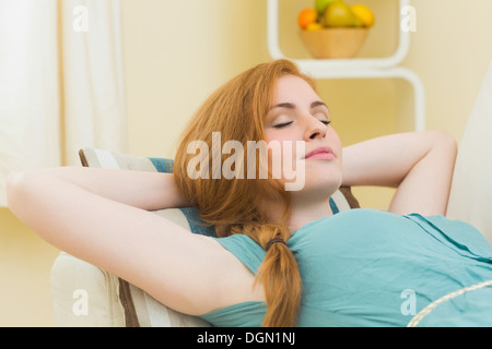 Peaceful redhead lying on the couch asleep Stock Photo