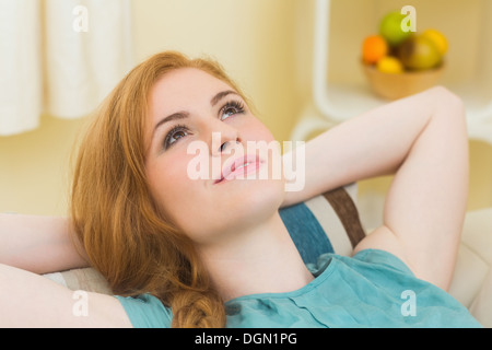 Calm redhead lying on the couch looking up Stock Photo