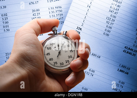 Hand holding stopwatch on budget numbers Stock Photo
