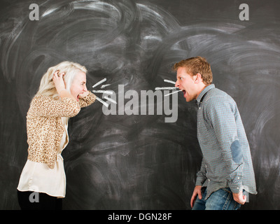 Studio portrait of young couple shouting at each other Stock Photo