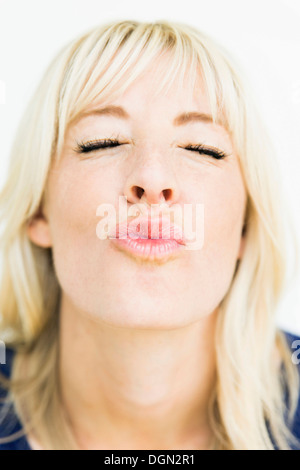 Studio portrait of blonde woman puckering Stock Photo