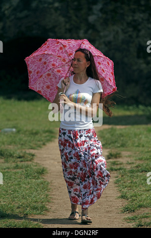 LADY WITH PINK PARASOL & FLORAL DRESS GALLE SRI LANKA 17 March 2013 Stock Photo