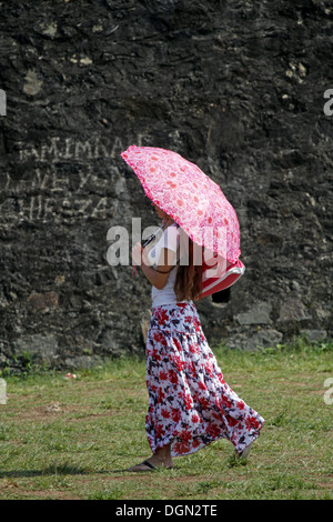 LADY WITH PINK PARASOL & FLORAL DRESS GALLE SRI LANKA 17 March 2013 Stock Photo