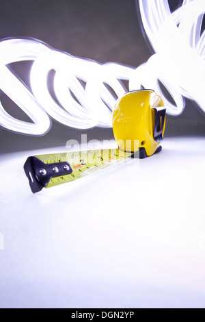 Bright yellow tape measure with light streaks Stock Photo