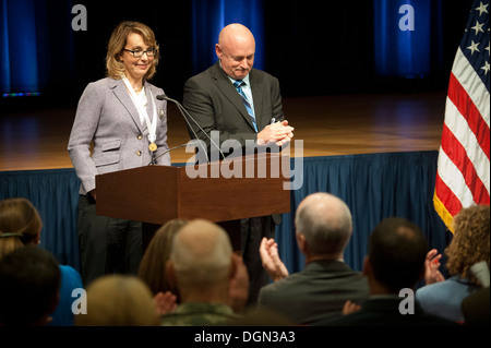 Former Rep. Gabrielle 'Gabby' Giffords (Ariz.) being applauded by her husband, retired Navy Capt. Mark Kelly as well as the rest of the audience during her remarks just after she was presented with the Army Decoration for Distinguished Civilian Service fo Stock Photo