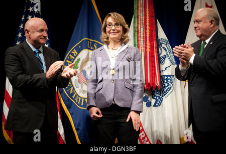Former Rep. Gabrielle 'Gabby' Giffords (Ariz.) being applauded by Under Secretary of the Army Joseph W. Westphal (far right) and her husband retired Navy Capt. Mark Kelly (far left) just after she was presented with the Army Decoration for Distinguished C Stock Photo