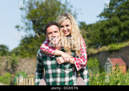 Young man giving his girlfriend a piggyback ride Stock Photo