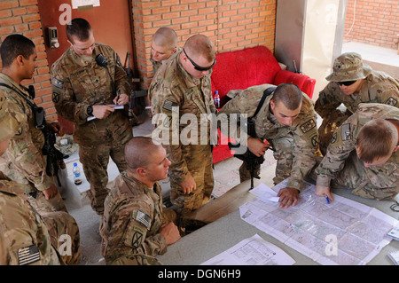 Soldiers from Company A, 2nd Battalion, 4th Infantry Regiment, use a map to sharpen their map reading skills and while their squad mates behind them go over notes from the Sergeant's Time training class they just received on map reading at Forward Operati Stock Photo