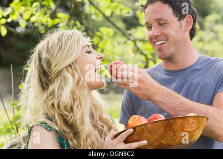 Young man feeding his girlfriend with an apple Stock Photo