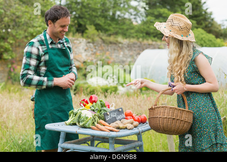 Beautiful blonde woman buying vegetables at farmers market Stock Photo