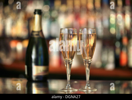 A champagne bottle and two glasses of champagne on a bar Stock Photo