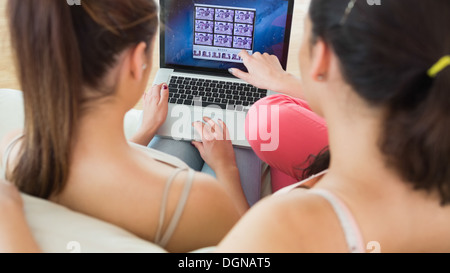 Two brunette young women working with a laptop Stock Photo