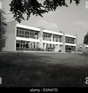 1960s, exterior view of a newly built 'modern' school building, with the architectural style of the day, large window panels and pre-cast concrete, England, UK. Made offsite, the extensive window panels had the benefit of bringing greater light into the classrooms and were cheaper to build as they were mass produced. Together with the use of concrete they reduced the need for brickworks and skilled labour, thus reducing costs. The problem with these modern buildings were that they did not weather well and overtime required lots of maintenance and repairs, and so were subsquently pulled down. Stock Photo