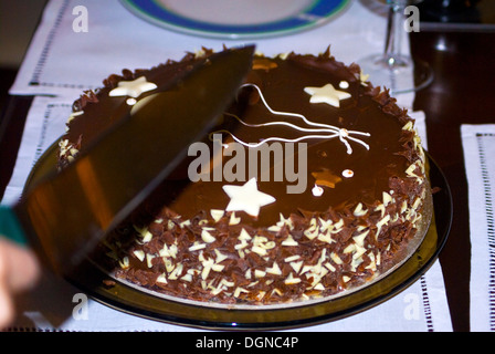 Hand cutting a  cake with decoration Stock Photo