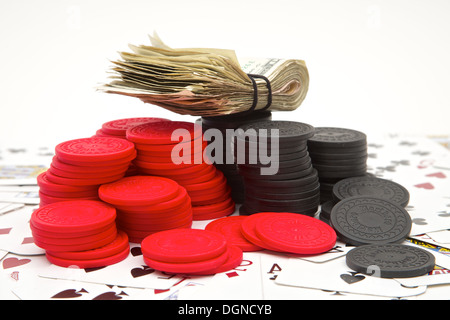 A stack of money and poker chips on a pile of playing cards Stock Photo