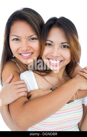 Two pretty sisters embracing in front of the camera Stock Photo