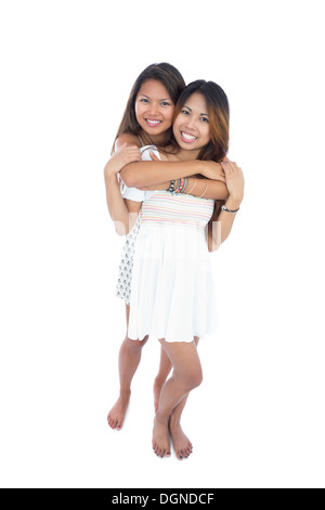 Two pretty sisters hugging in front of the camera Stock Photo