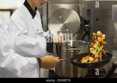 Two chefs working in a busy kitchen Stock Photo