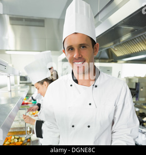 Handsome male chef posing in the kitchen Stock Photo