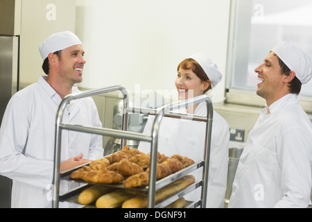 Three young chatting bakers standing in a kitchen Stock Photo