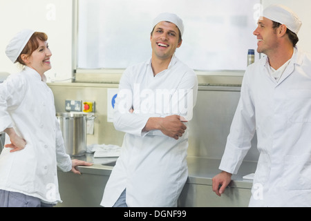 Three chatting bakers standing in a bakery Stock Photo