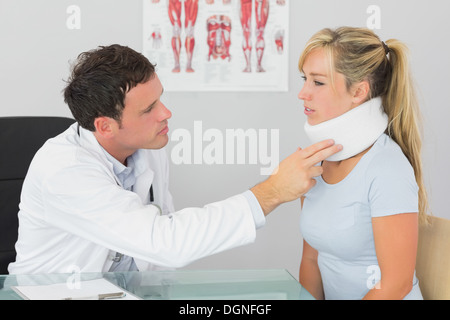 Attractive doctor examining neck of a patient Stock Photo