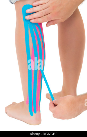 Woman applying blue kinesio tape on the injury knee Stock Photo - Alamy