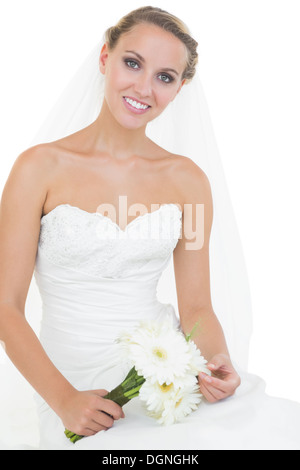 Lovely bride sitting on ground holding a bouquet Stock Photo