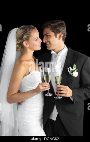 Gorgeous young married couple posing holding champagne glasses Stock Photo