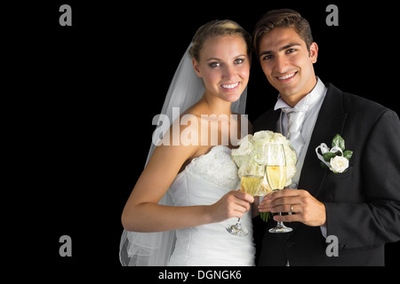 Happy young married couple posing holding champagne glasses Stock Photo