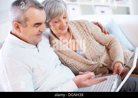 Portrait of mature man and his wife working with laptop at home Stock Photo