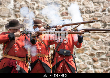 Soldiers firing flintlock muskets in re-enactment French & Indian American Revolution Revolutionary War of Independence Stock Photo