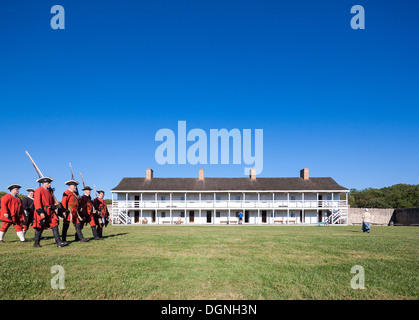 Historic 18th century daily life in Fort Frederick Maryland. Volunteers march with period uniforms and muskets. East barracks. Stock Photo