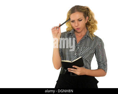 Beautiful, worried woman with black notebook and pen in hand. Stock Photo