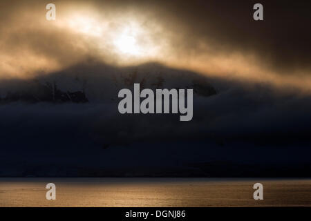 Low-standing sun shining through dense cloud cover, Errera Channel, Arctowski Peninsula, Antarctic Peninsula, Antarctica Stock Photo