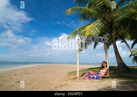 Tourist lying under a sign with the words Puerto Rico, Luquillo Beach, Puerto Rico, Caribbean Stock Photo