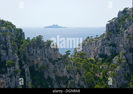 Karst rocks in the rocky bay Calanque d'En-Vau, Ile de Riou at back, Calanques National Park, Cassis, Département Stock Photo