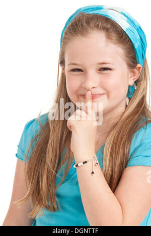 Girl, 8 years, holding a finger to her lips Stock Photo