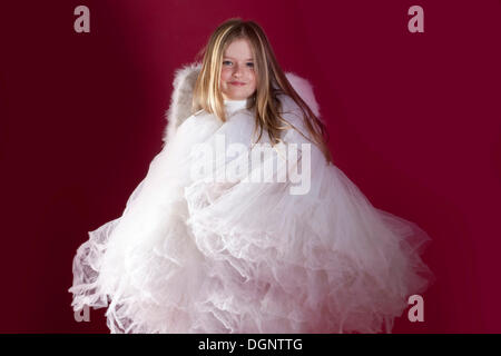 Girl, 8 years, in a white dress with angel wings Stock Photo