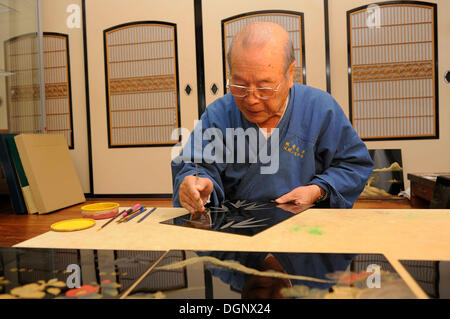 Japanese artisan in his workshop, scraping a bamboo motif into the top lacquer coat, Sabae, Fukui, Japan, East Asia, Asia Stock Photo