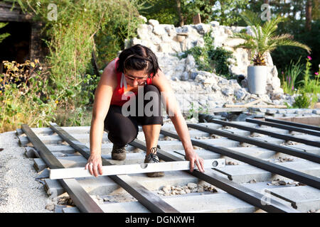 Woman, 40, using a spirit level during the construction of a patio, Austria, Europe Stock Photo