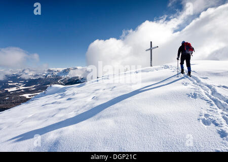 Winter hiker during ascending Schwarzhorn Mountain on Jochgrimm, here on the summit ridge, Latemar Mountain at the rear Stock Photo