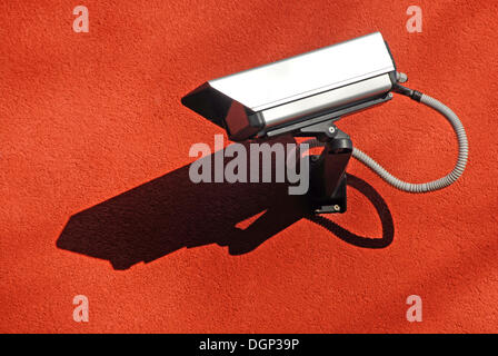 Surveillance camera on a red wall Stock Photo