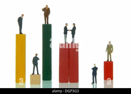 Business men figurines standing on a bar chart, symbolic picture for industry Stock Photo
