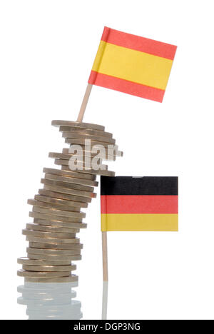 Wobbly stack of Euro coins supported by a German flag, a Spanish flag on top, symbolic image for financial crisis of the Euro Stock Photo