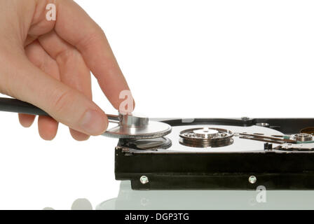 Female hand with a stethoscope on a hard drive, symbolic image for data analysis, data backup, data recovery Stock Photo